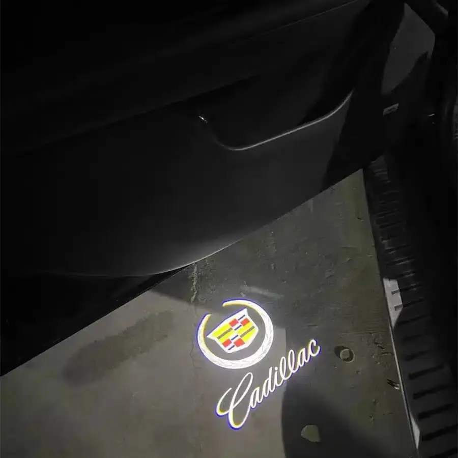 Cadillac logo projected on the ground near a car door, with a colorful emblem and cursive "Cadillac" text, creating a luxury and elegant ambiance.